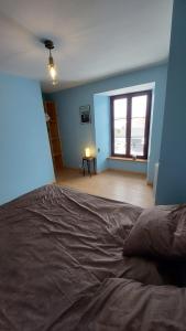 - une chambre avec un grand lit et une fenêtre dans l'établissement Chez Maritou, à Besse-et-Saint-Anastaise