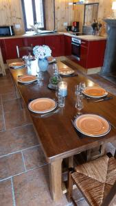 - une table en bois avec des assiettes dans la cuisine dans l'établissement Chez Maritou, à Besse-et-Saint-Anastaise