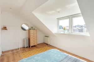 um quarto branco com uma cama e uma janela em Argyll Apartments - Argyll Square, Oban em Oban