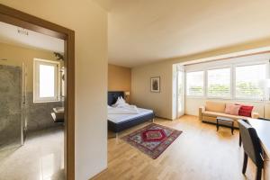 a bedroom with a bed and a living room at Hotel Residence Pernhof in Termeno