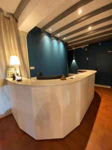 un hall avec un comptoir blanc et un mur bleu dans l'établissement Logis Hôtel Médiéval, Montélimar Nord, à Rochemaure