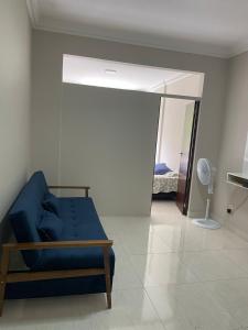 sala de estar con sofá azul y espejo en Apê da Lê, en Río de Janeiro