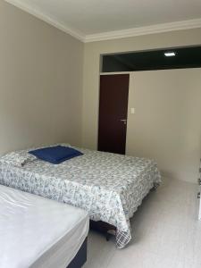 1 dormitorio pequeño con 2 camas y puerta en Apê da Lê, en Río de Janeiro