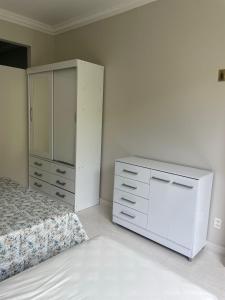 1 dormitorio con cama blanca y vestidor en Apê da Lê, en Río de Janeiro