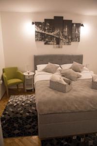 a bedroom with two beds and a green chair at Studio Apartman SubUrban in Višnjevac
