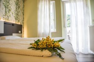 un ramo de flores amarillas sentado en una cama en Hotel Eden, en Torri del Benaco
