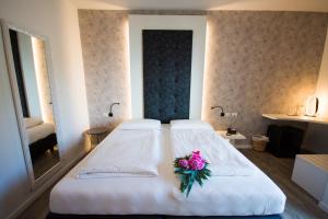 a bedroom with a white bed with a flower on it at Hotel Eden in Torri del Benaco