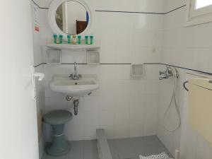 uma casa de banho com um lavatório, um WC e um espelho. em Silver Rocks Hotel em Chrissi Akti