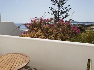 a white wall with a bench and flowers on it at Silver Rocks Hotel in Chrissi Akti
