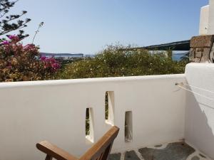 a chair on a balcony with a view of the ocean at Silver Rocks Hotel in Chrissi Akti