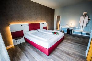 a large bedroom with a large bed with red accents at Hotel Eden in Torri del Benaco