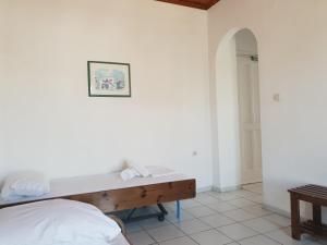 a white room with a bed and a desk at Silver Rocks Hotel in Chrissi Akti