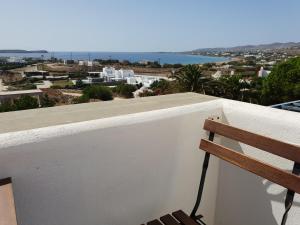 a bench sitting on a balcony with a view of the ocean at Silver Rocks Hotel in Chrissi Akti