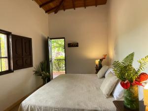 a bedroom with a large bed and a window at MuchoSur Quimbaya in Quimbaya