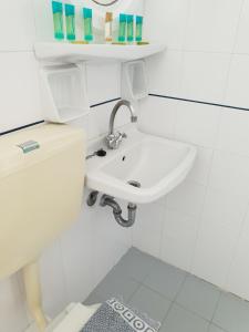 a white bathroom with a sink and a toilet at Silver Rocks Hotel in Chrissi Akti