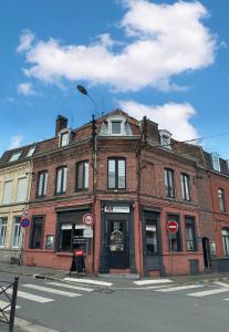 a brick building on the corner of a street at Suite dernier étage Saint-Maur in La Madeleine
