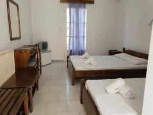 a small room with two beds and a television at Silver Rocks Hotel in Chrissi Akti