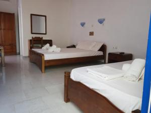 a bedroom with two beds and a mirror at Silver Rocks Hotel in Chrissi Akti