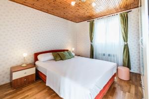 sypialnia z dużym białym łóżkiem i oknem w obiekcie Holiday home Marina-renovated house in city center w Rogoznicy