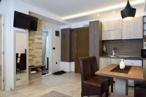 a kitchen and living room with a table and a dining room at Apartmani Leki in Kopaonik