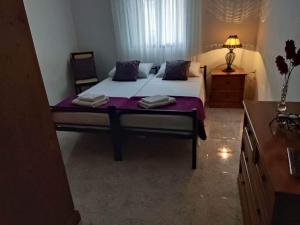 una camera da letto con un grande letto con lenzuola viola di St Julian's Twin Room In A Private House a San Giuliano
