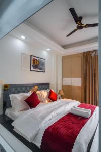 a bedroom with a large bed with red pillows at The Lodgers 1 BHK Serviced Apartment Golf Course Road Gurgaon in Gurgaon
