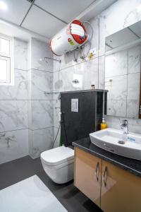a bathroom with a toilet and a sink at The Lodgers 1 BHK Serviced Apartment Golf Course Road Gurgaon in Gurgaon