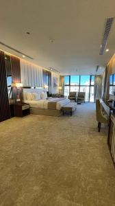 um grande quarto de hotel com uma cama e uma secretária em White House Apartments em Khamis Mushayt