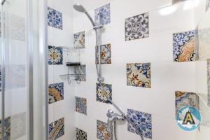 a bathroom with a shower with blue and white tiles at Comodo a due passi dal mare 46a in Silvi Paese +13 photos