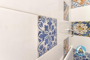 a bathroom with blue and white tiles on the wall at Comodo a due passi dal mare 46a in Silvi Paese