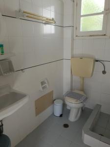 a white bathroom with a toilet and a sink at Silver Rocks Hotel in Chrissi Akti