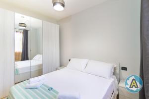 a bedroom with a white bed and a mirror at Comodo a due passi dal mare 46a in Silvi Paese
