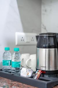 eine Küchentheke mit zwei Flaschen Wasser und einem Mixer in der Unterkunft The Lodgers 1 BHK Serviced Apartment Golf Course Road Gurgaon in Gurgaon