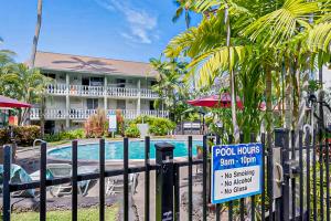 een bord op een hek voor een huisje bij het zwembad bij Kona Islander Inn 147 Tropical Oasis in Kailua-Kona