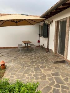 een patio met een tafel en stoelen en een parasol bij La Casina di Bice-Casa mia in Casa Mora