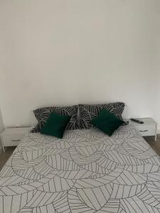 a bedroom with a large bed with two green pillows at L&M Apartment in Târgu-Mureş