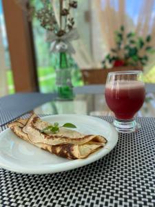a plate of food and a drink on a table at Pousada Vale do Chapéu in Capitólio