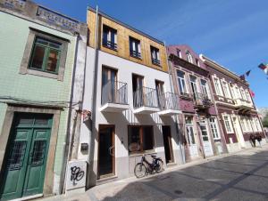 a row of buildings on a street with a bike parked in front at Sardines and Friends Hostel 04 in Póvoa de Varzim
