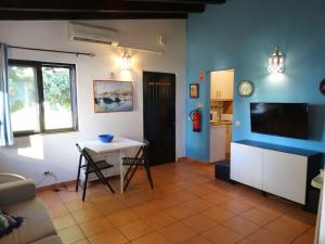 un soggiorno con tavolo e TV di My cozy BEACH HOUSE a Tavira