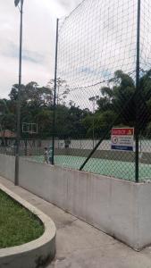 a tennis court with a net on a tennis court at Ubatuba Apartamento temporada in Ubatuba