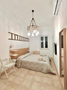 a bedroom with a large bed and a chandelier at Casa Perricci - short lets - Monopoli (BA) in Monopoli