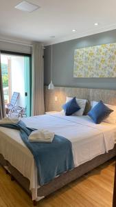 ein Schlafzimmer mit einem großen Bett mit blauen Kissen in der Unterkunft Pousada Vale do Chapéu in Capitólio