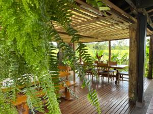 eine Holzterrasse mit einem Tisch und Stühlen in der Unterkunft MuchoSur Quimbaya in Quimbaya