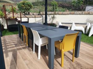 un tavolo blu e sedie gialle su un patio di Villa Ancon 116 ad Arona