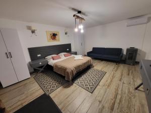 a bedroom with a bed and a blue couch at Elis Tranzit in Ogrăzile +36 photos