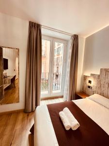 a bedroom with a bed and a large window at Hostal Anton Martin in Madrid