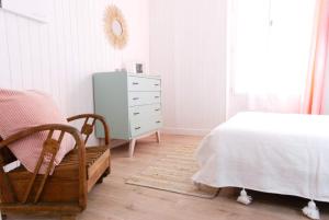 a bedroom with a bed and a dresser and a mirror at La Mariennée in La Rochelle
