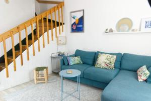 Una sala de estar con un sofá azul y escaleras. en La Mariennée, en La Rochelle 32 fotos más
