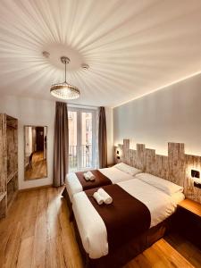 a bedroom with a large bed and a chandelier at Hostal Anton Martin in Madrid