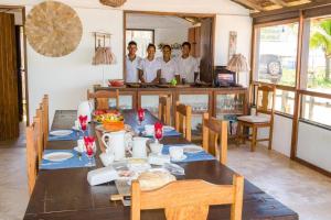 a group of men standing in a kitchen with a table at Pousada Loin de Tout in Corumbau